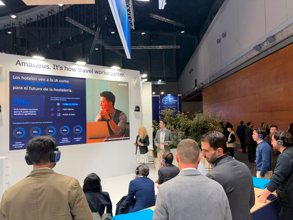 Público con auriculares siguiendo una ponencia en el Ágora del stand de un líder global en travel tech en FITUR 2026