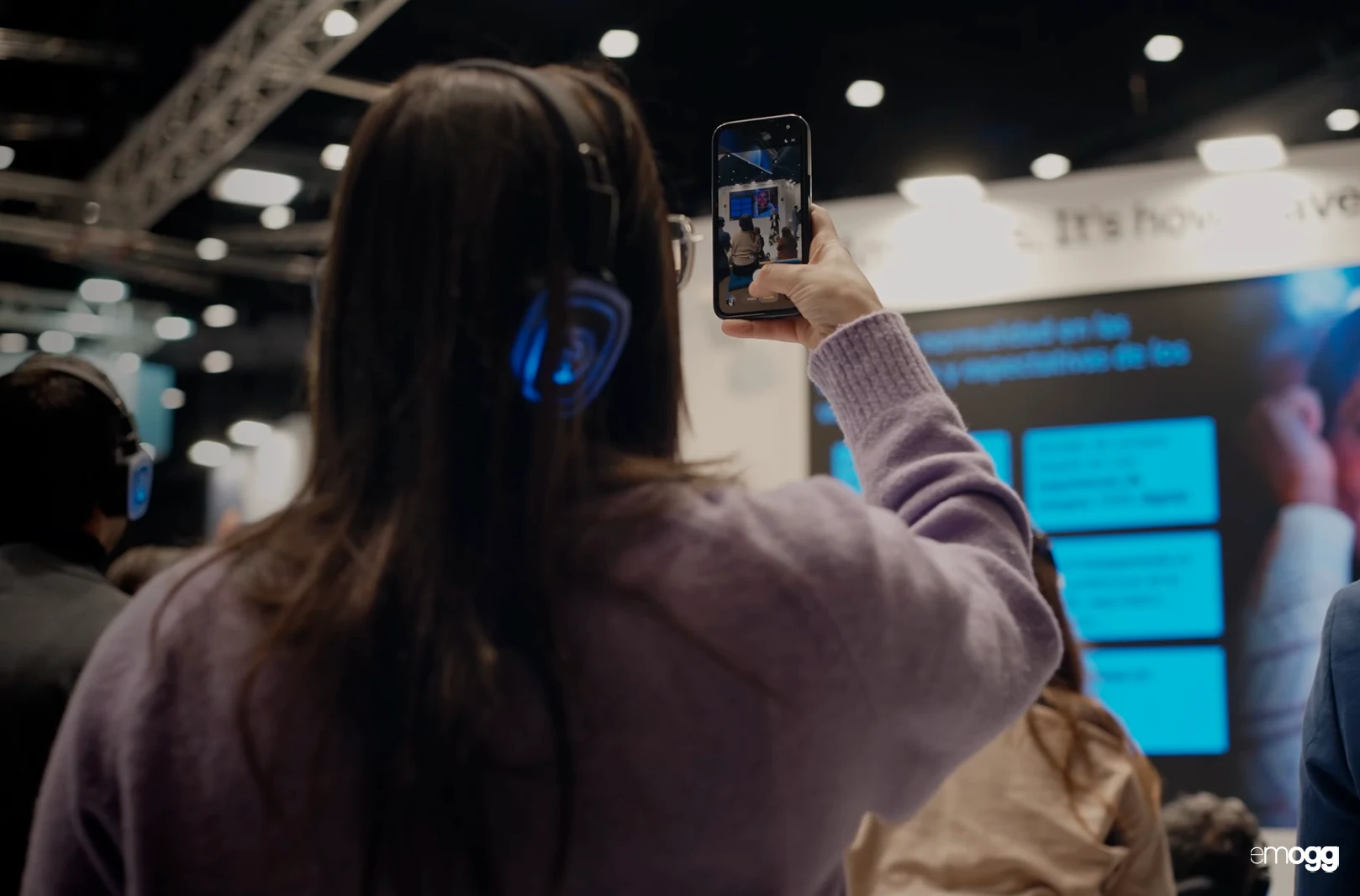 Público con auriculares siguiendo una ponencia en el Ágora del stand de Amadeus en FITUR 2026