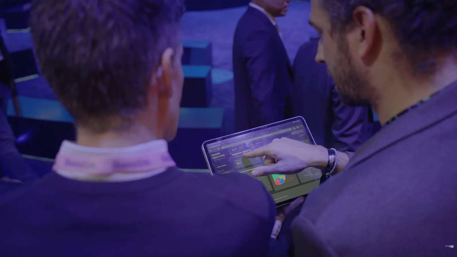Dos asistentes revisan el panel de Emogg Analytics en una tablet